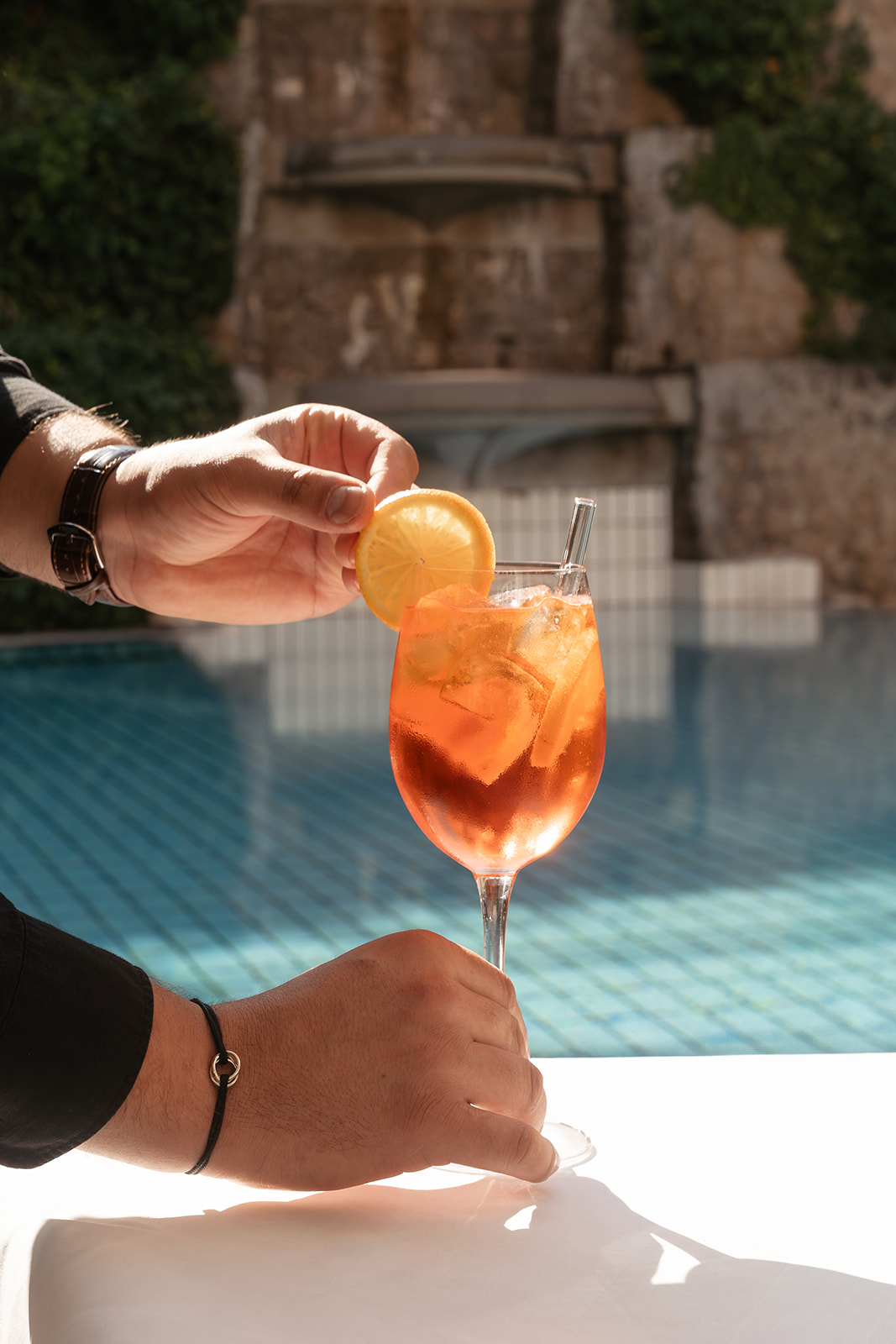 Cocktail mit einer Zitronenscheibe wird am Pool serviert, ideal für eine entspannte Sommeratmosphäre.