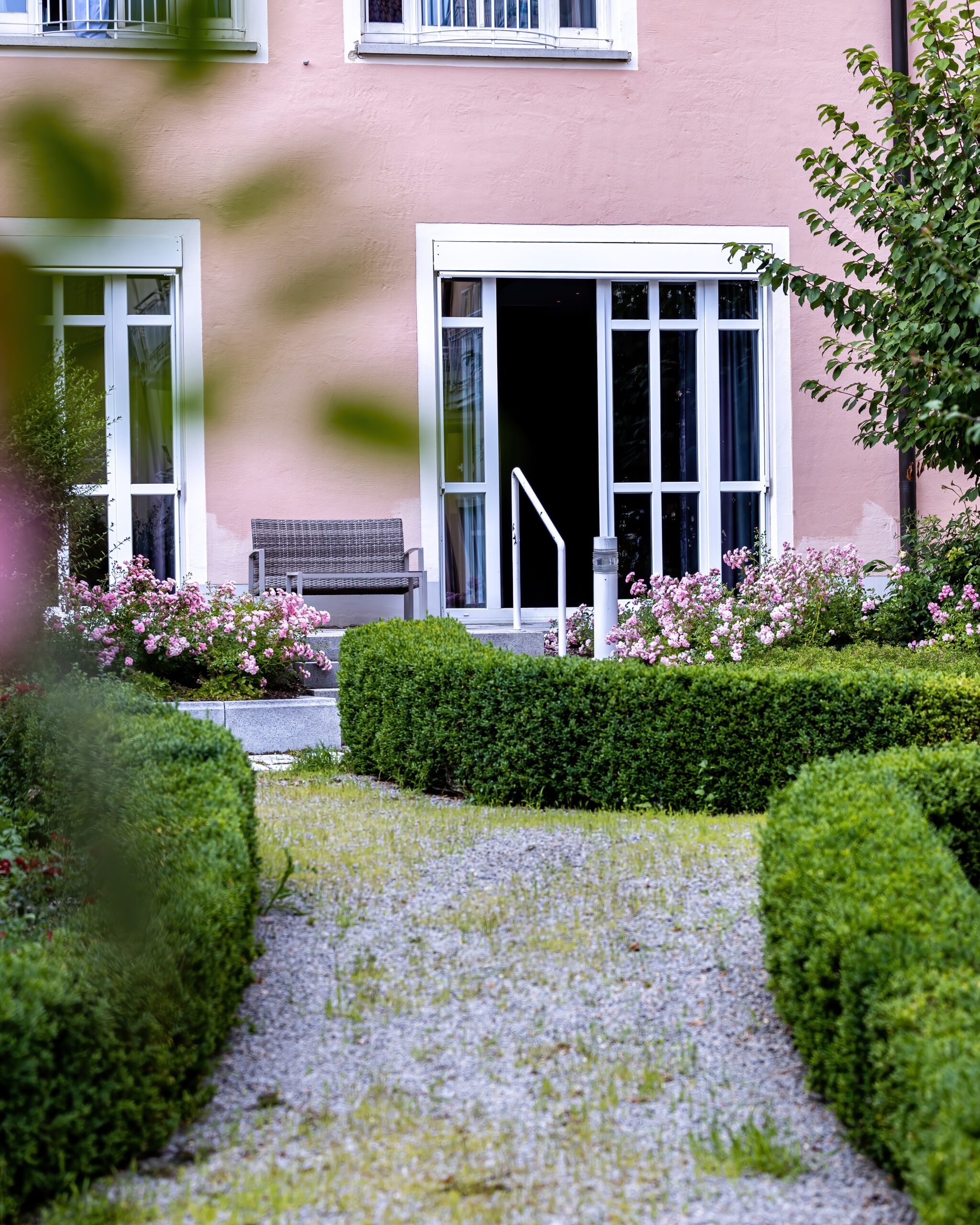 Außenansicht eines modernen Gebäudes mit großen Fenstern und einer Tür, die zu einem Konferenzraum führt