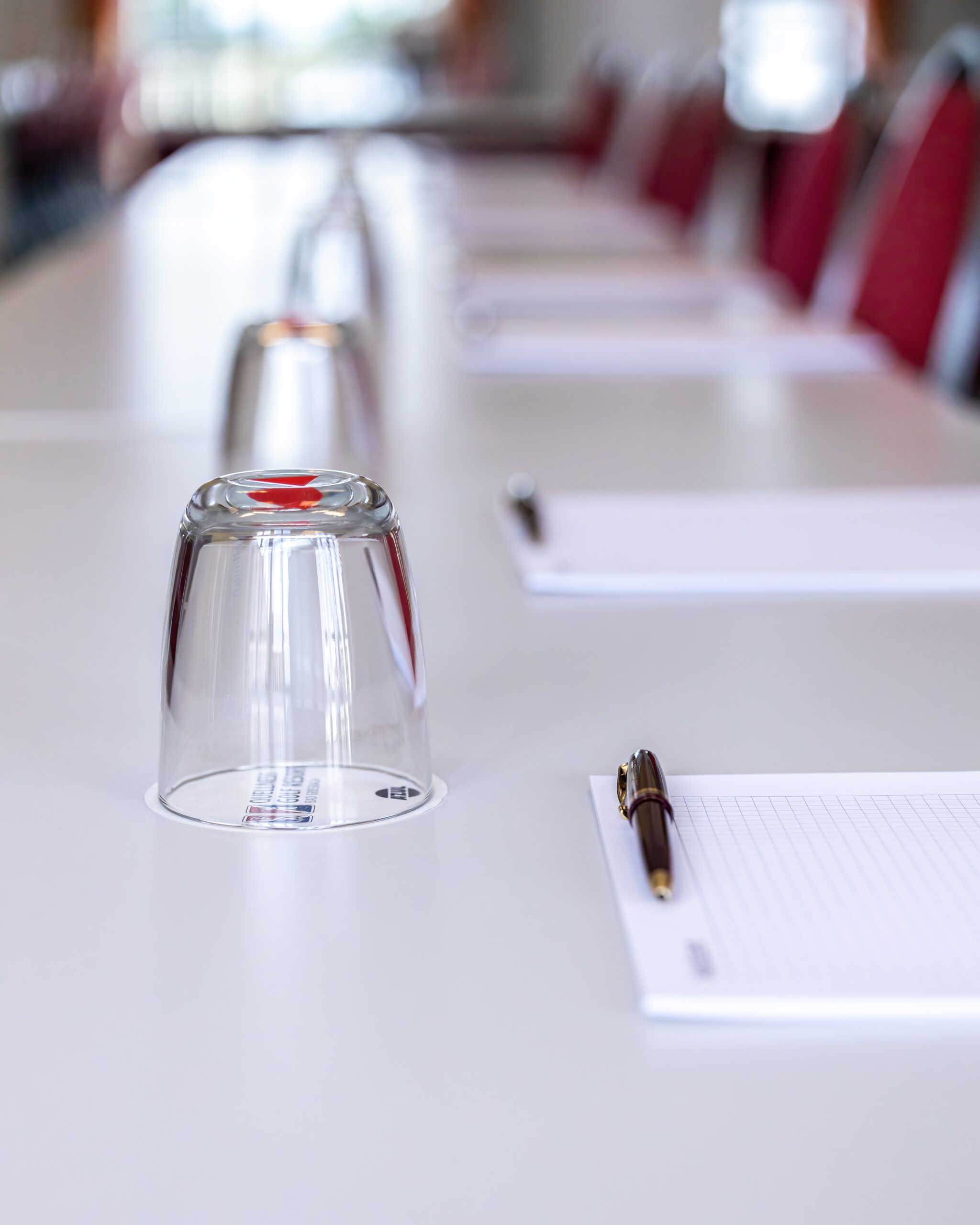 Reihen von roten Stühlen in einem modernen Konferenzraum, vorbereitet für eine Veranstaltung oder Tagung